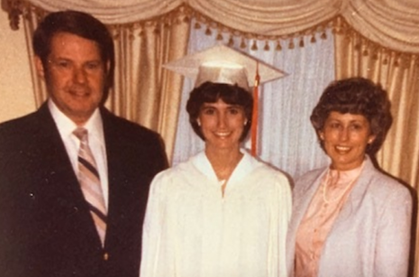 Margo Monteith stands with her parents in her cap and gown