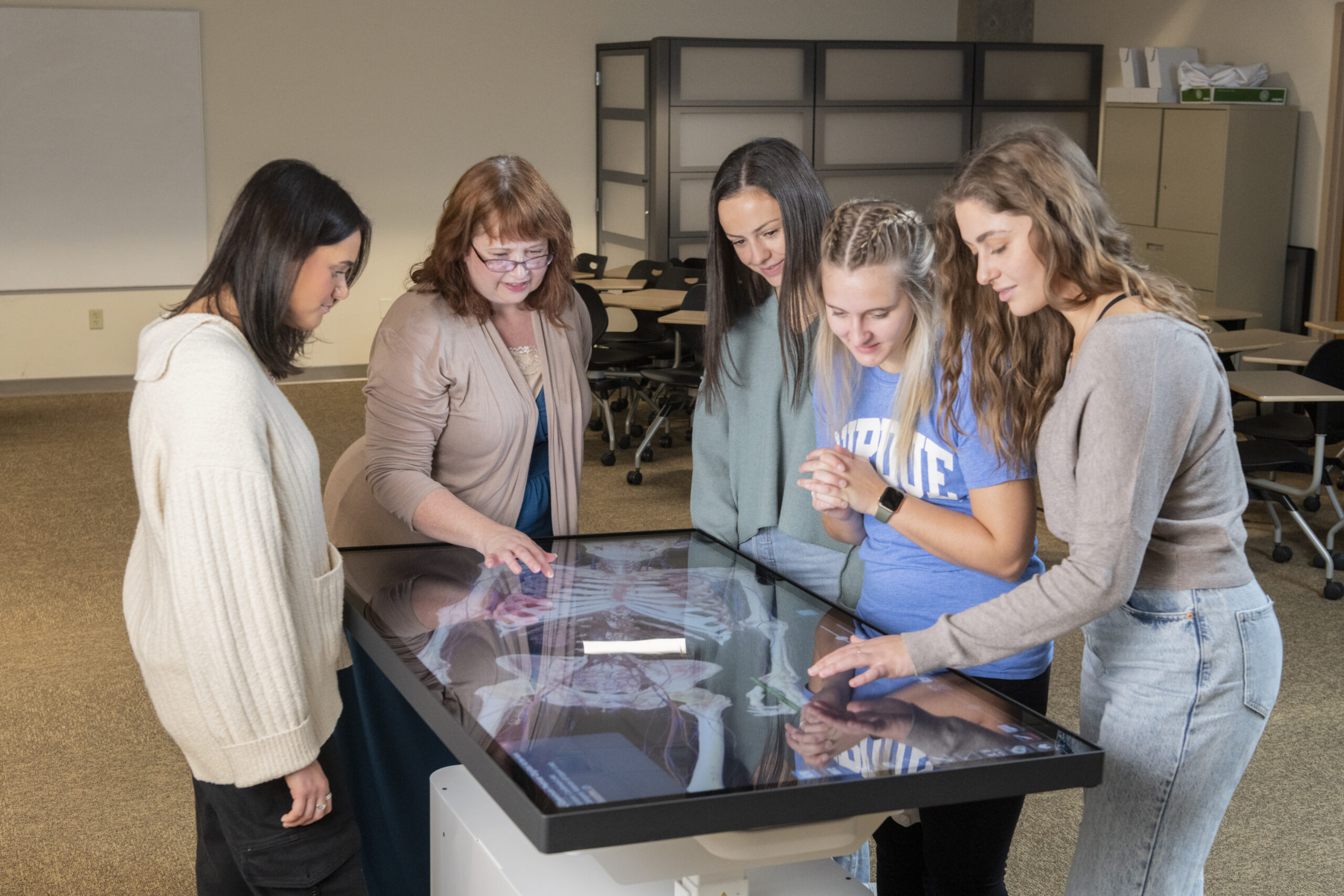 Lisa Hilliard and four of her students stand around an Anatomage Clinical Table.