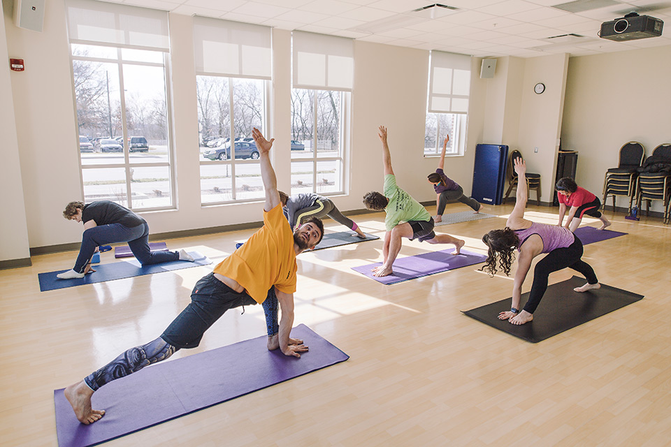 Caleb Mickschi leads a yoga class at the Ismail Center