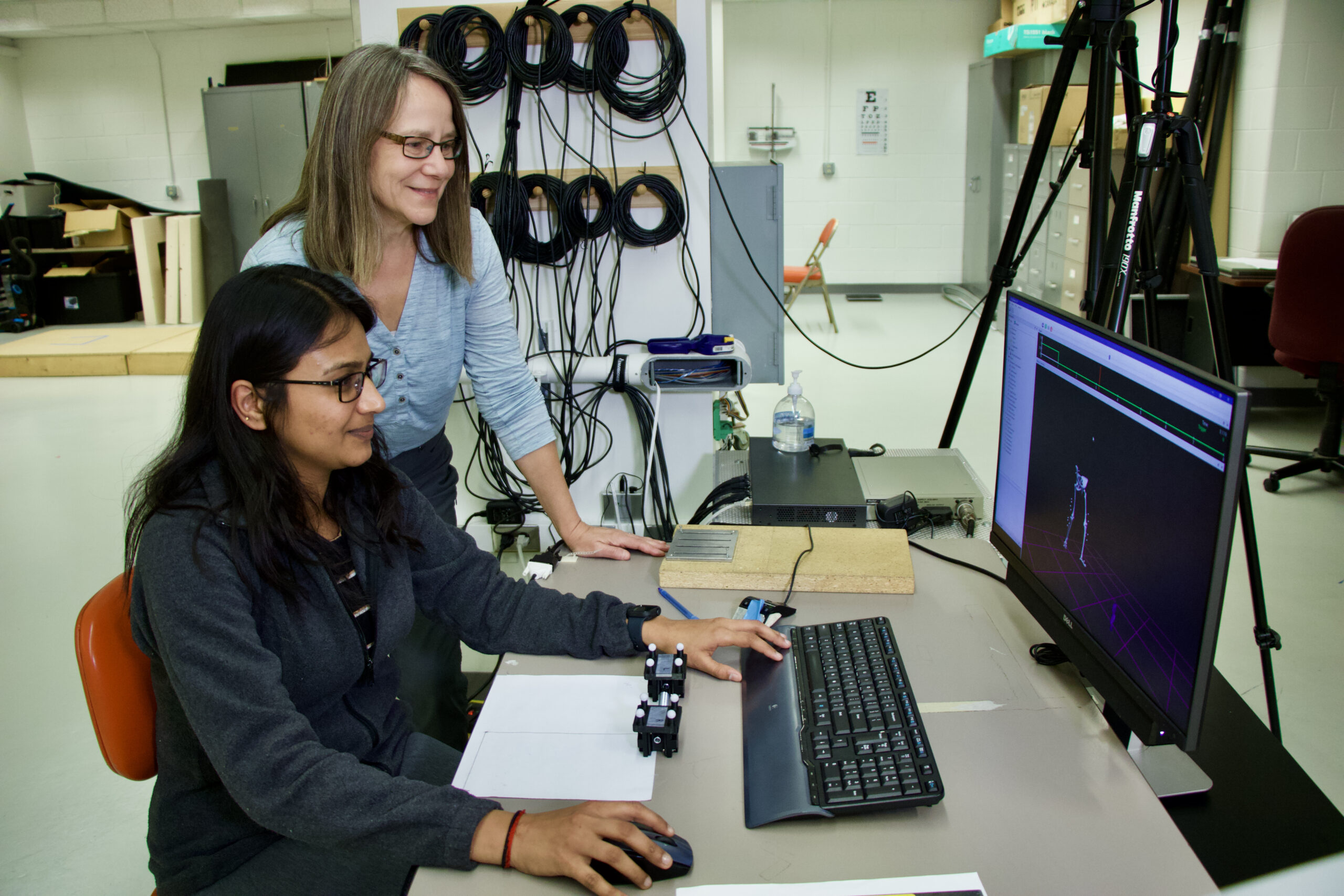 Shirley Rietdyk looks at a computer monitor while Ashwini Kulkarni sits at the computer.