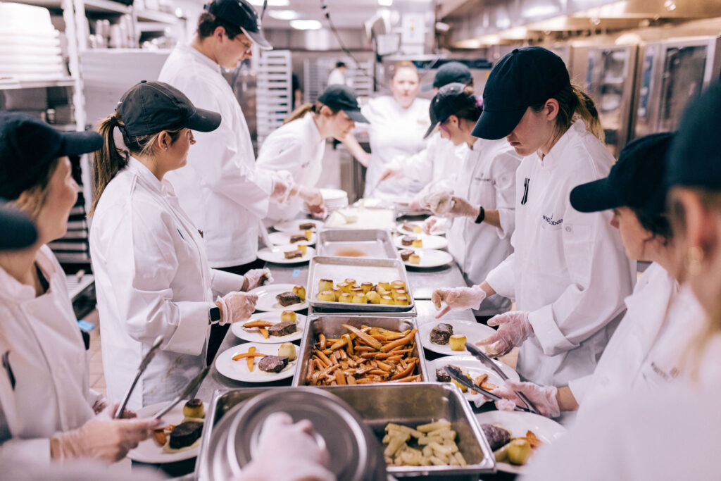 Several kitchen volunteers prepare food.