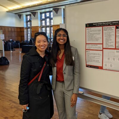Xu poses with one of her students in front of a research poster