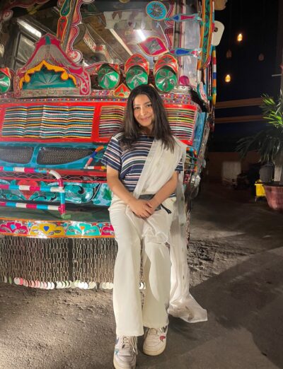 Sameeta Chunara stands in front of colorful backdrop in Pakistan