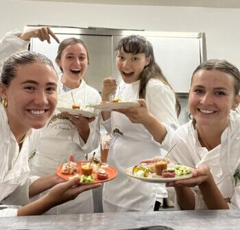 Shank and other students in the study abroad program pose with plates of food after a cooking class.