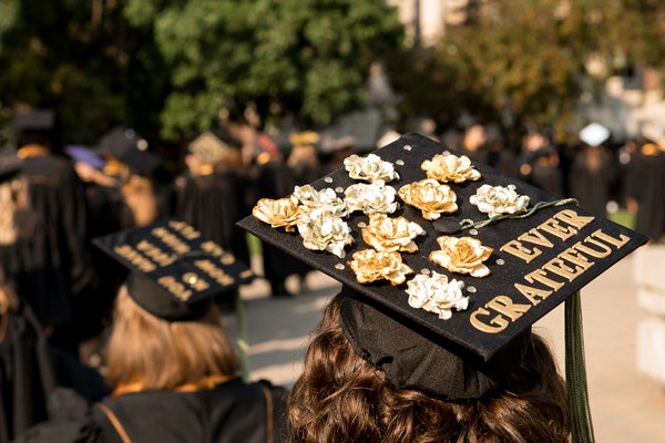 Student walks in line with graduation cap that says "Ever Grateful."