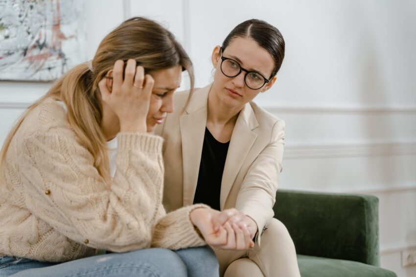 A woman comforts another woman in distress