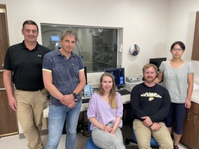 Researchers pose for photo in the Purdue Life Science MRI Facility control room.