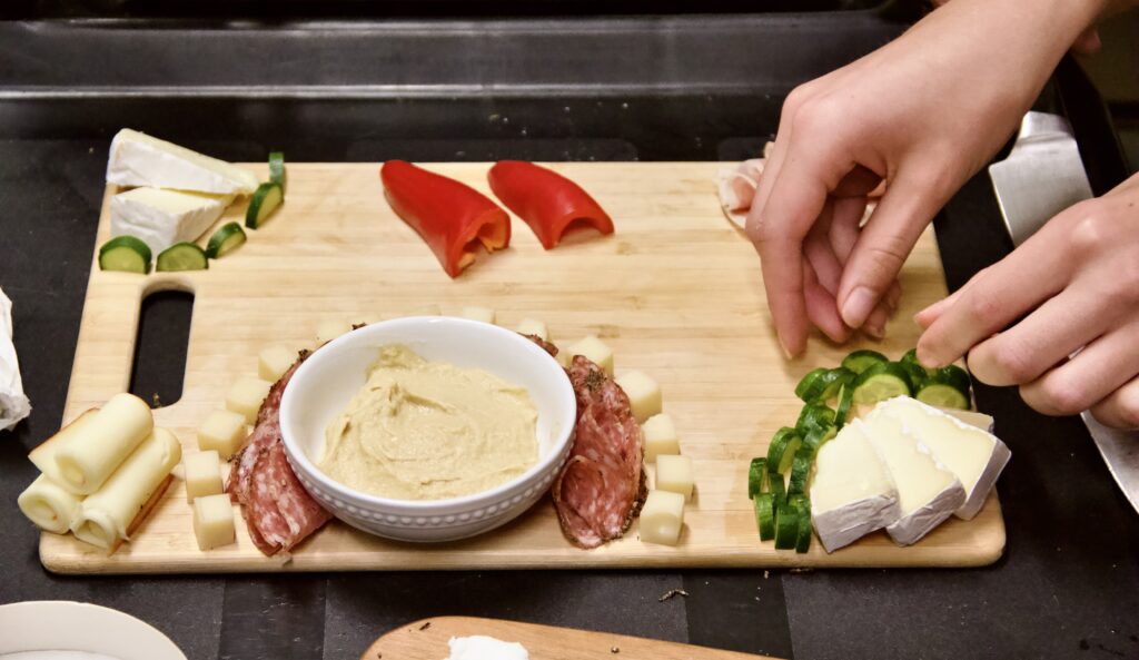 A student prepares a charcuterie board