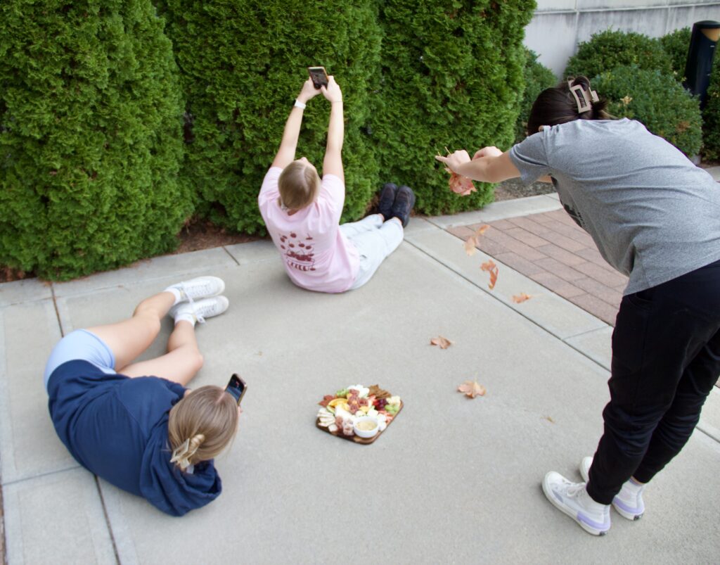 Students get all the angles and drop leaves for a photo shoot.