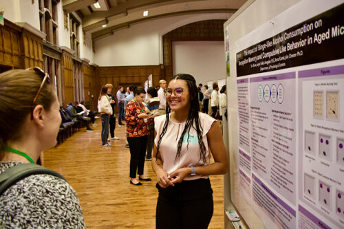 Tori Burke presents her research poster to one of the judges
