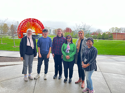 Baloni poses for a photo with the students from her lab