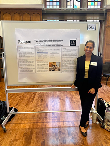 Emily Deldar stands in front of a research poster.