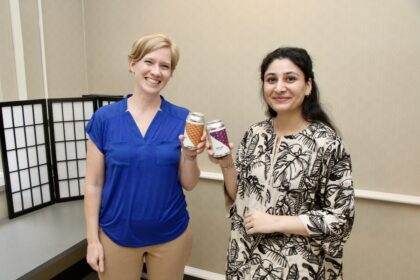 Cori Running and Wajiha Zulfiqar cheers cans of low-sugar soda made at Purdue.
