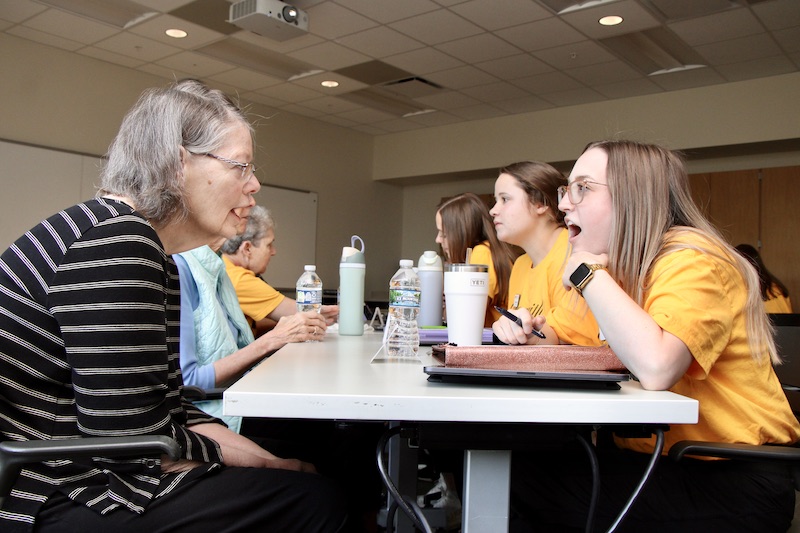 A woman and graduate student sit across from each other to work on vocal exercise.