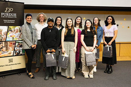 A group of people stand together, smiling.