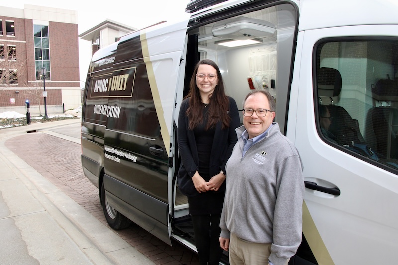 Michael Heinz and Alex Hustedt-Mai stand outside of the new APARC van for a photo.