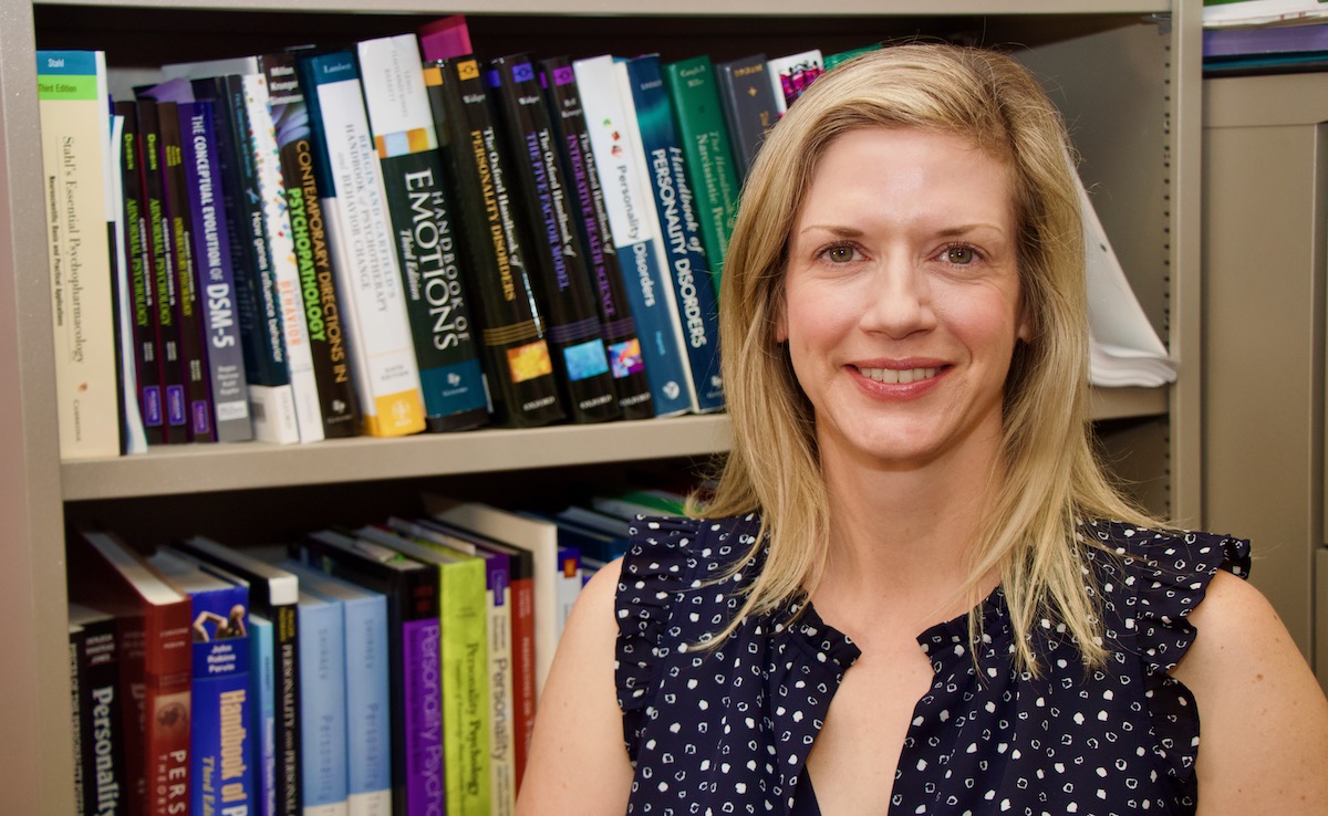 Susan South poses for a picture in front of a bookshelf.