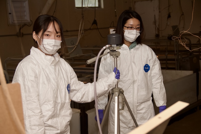Suboin Han and Nara Shin set up an air sampler inside a swine farrowing room.
