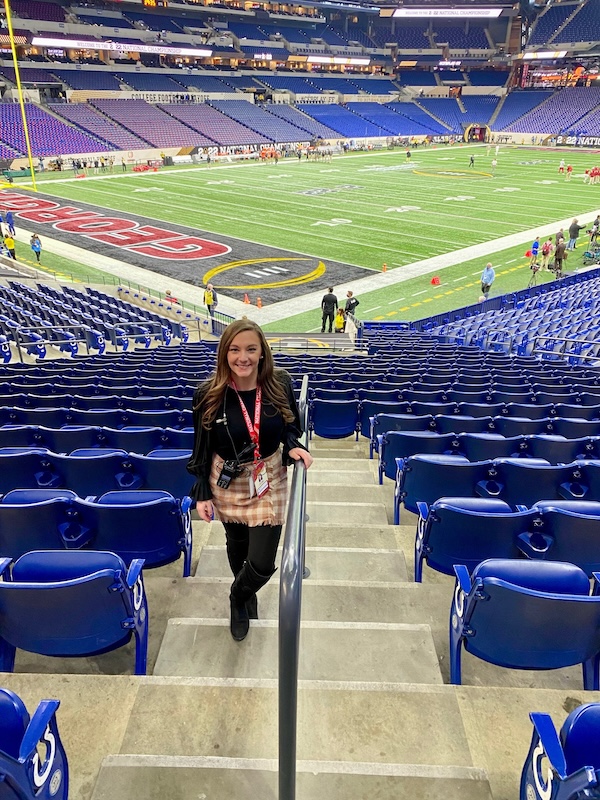 Taylor Bilger stands in an aisle close to the football field of Lucas Oil Stadium.