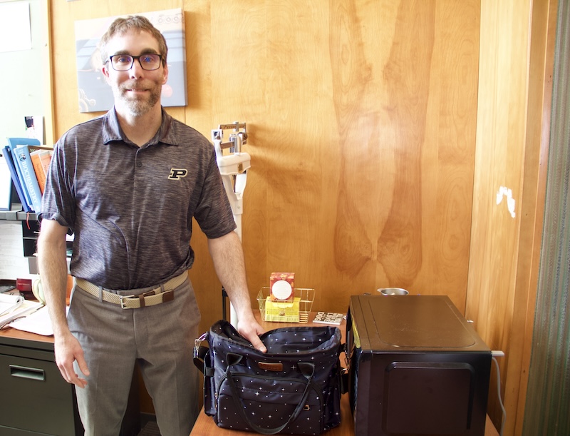 Greg Henderson poses for a photo with his lunch bag.