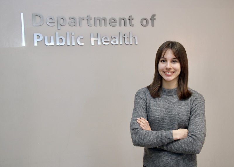 Hannah Hampson stands in front of the Purdue public health sign.