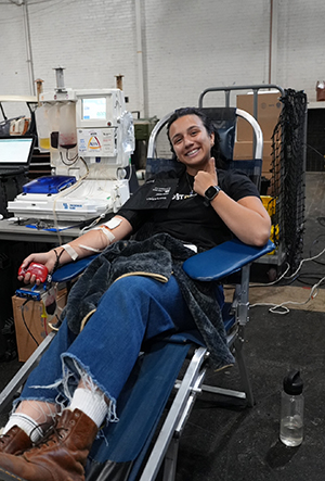 Pirbhai sits in a chair, donating blood.
