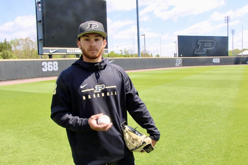 Quincy Malbrough holds a baseball in the outfield of Alexander Field.
