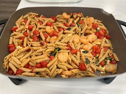 A pan of Basil, shrimp and tomato pasta with feta.