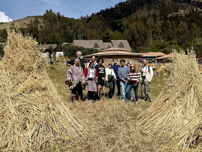 Jonathon Day and students stand in a field near a Peruvian village.