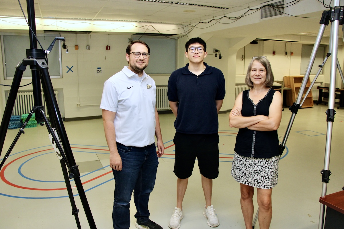 Brandon Kistler, Dave Kusni and Shirley Reitdyk stand near equipment in the Purdue motor behavior lab.