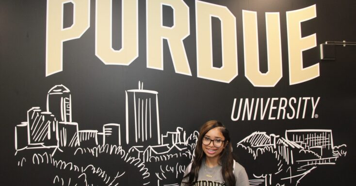 Harmony Oliver stands in front of a Purdue University mural inside the Engineering and Technology Building in Indianapolis