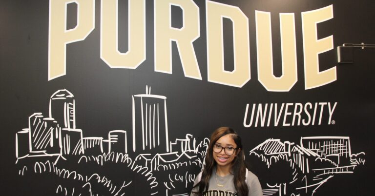Harmony Oliver stands in front of a Purdue University mural inside the Engineering and Technology Building in Indianapolis