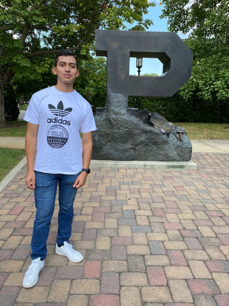 Eduardo Miranda standing in front of Purdue P statue