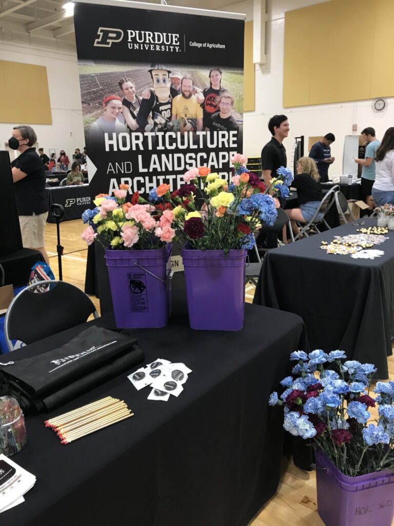 HLA Booth with buckets of flowers at the Rainbow Callout