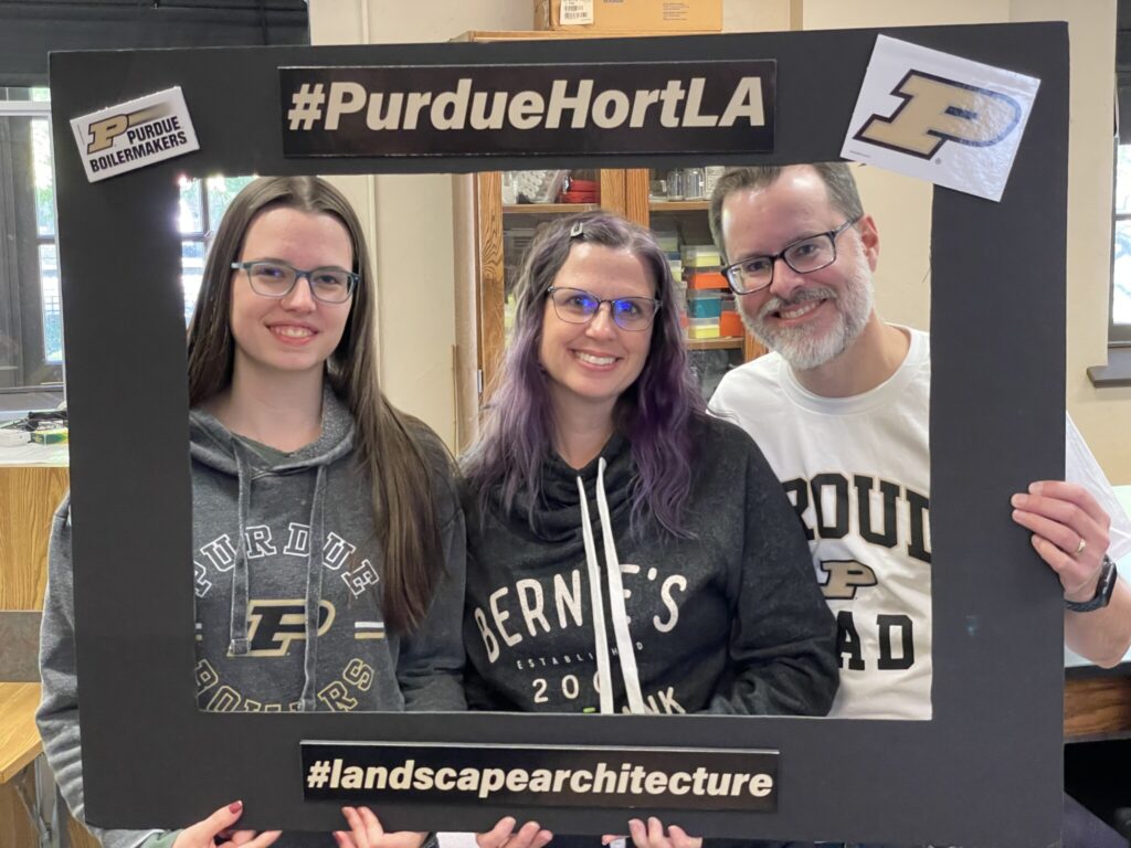 Student and her parents with cut-out Photo Booth frame