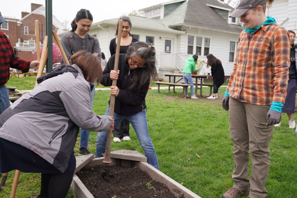 Attendees helps to work the soil for planting in a raised bed plot at the "Chew on This" event.