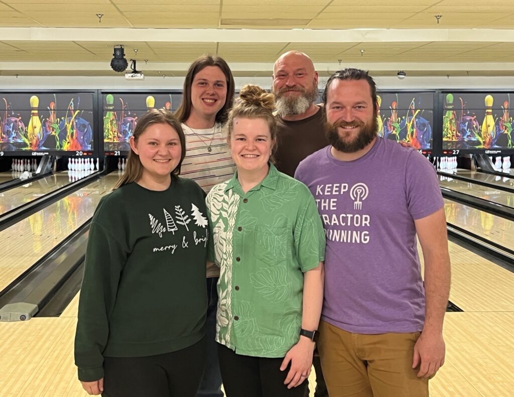 The five members of the HLA Bowling Team, Split Happens, posing in front of the bowling lanes.