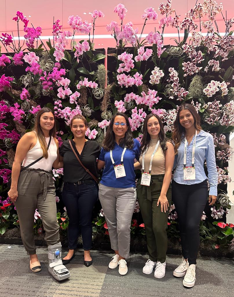 Sofia Gomez, Celina Gomez, Maria Paz (University of Florida), Lian Duron, and Dalne Wood standing in front of a flower/green wall.