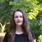 Erin Percevault standing with trees in the background.