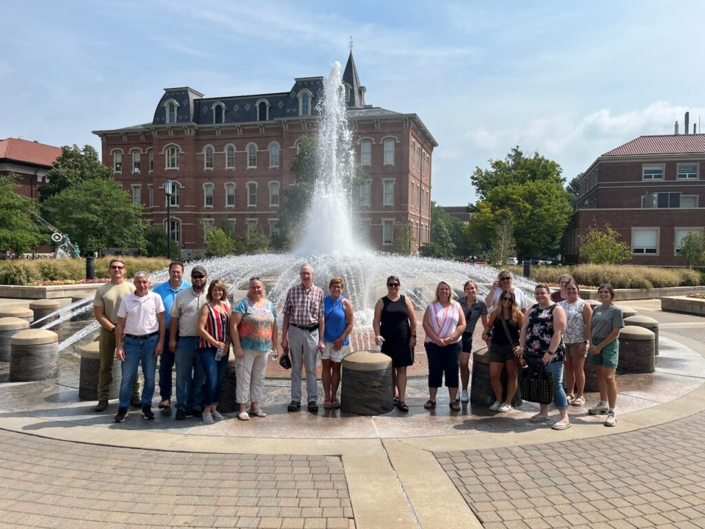 Attendees standing in front of a fountain on campus.