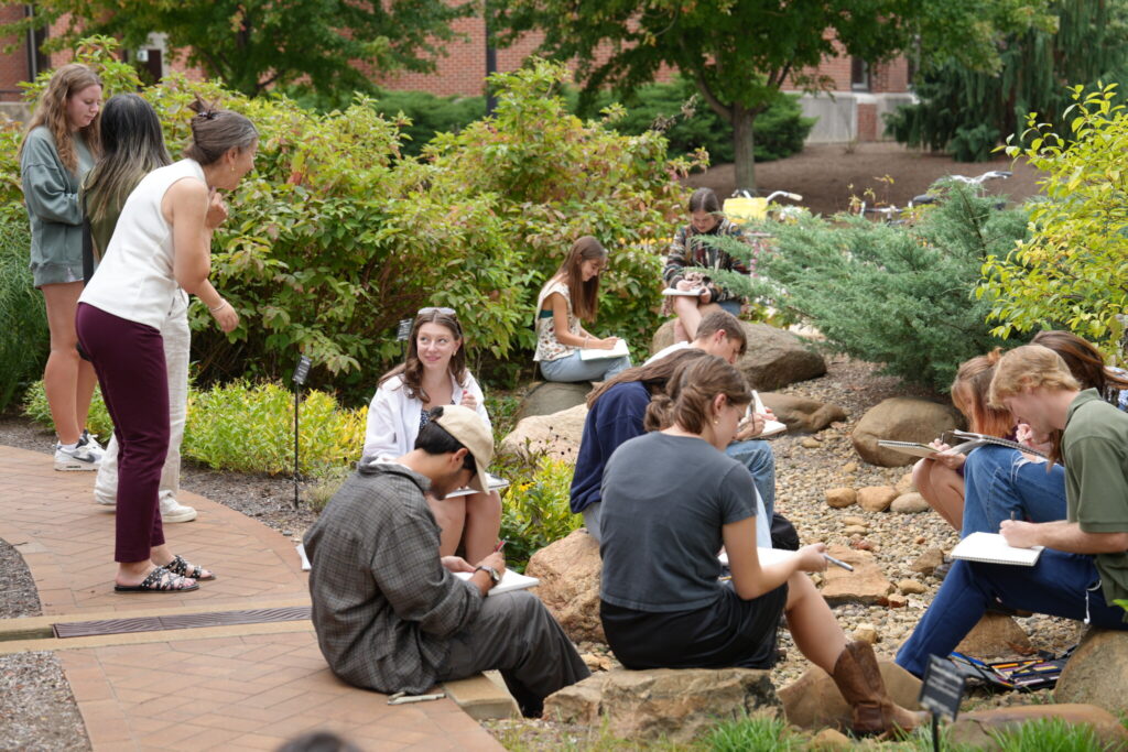 Students working on sketching in the rain garden.