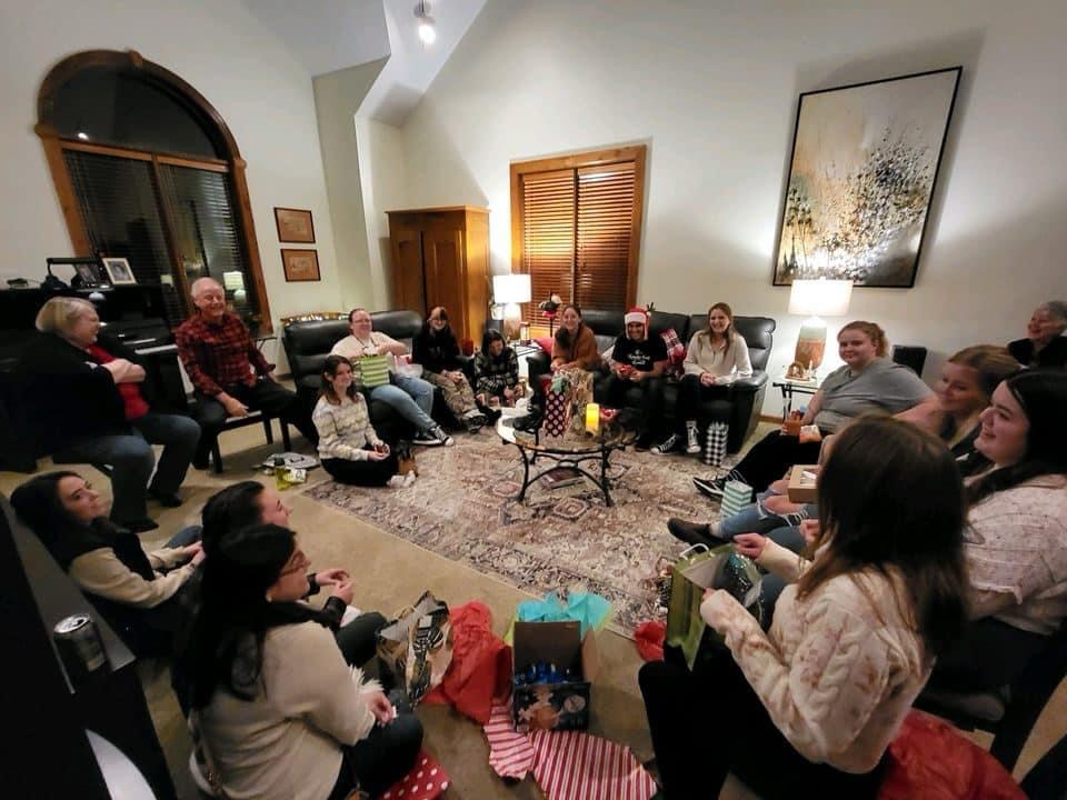 Purdue Hort Club Members setting around a living room with various holiday presents.