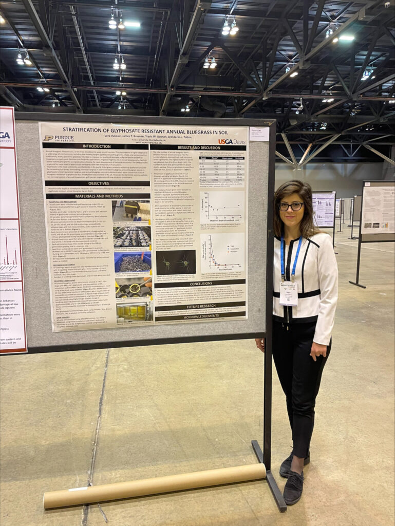 Vera Vukovic standing in next to her research poster.