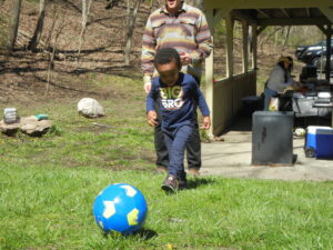 Toddler kicking a soccer ball.
