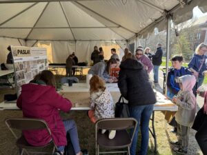 Children surrounding the PASLA table in the HLA tent