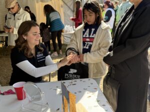 PASLA volunteer applying a temporary tattoo to a young girl.