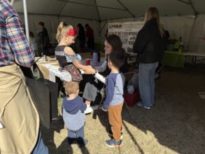PASLA volunteer applying a temporary tattoo to a young girl.