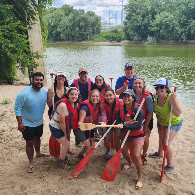 HLA voyageur canoe team on the river shore.