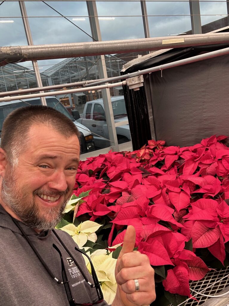 Nathan Deppe giving a thumbs up for the poinsettias.