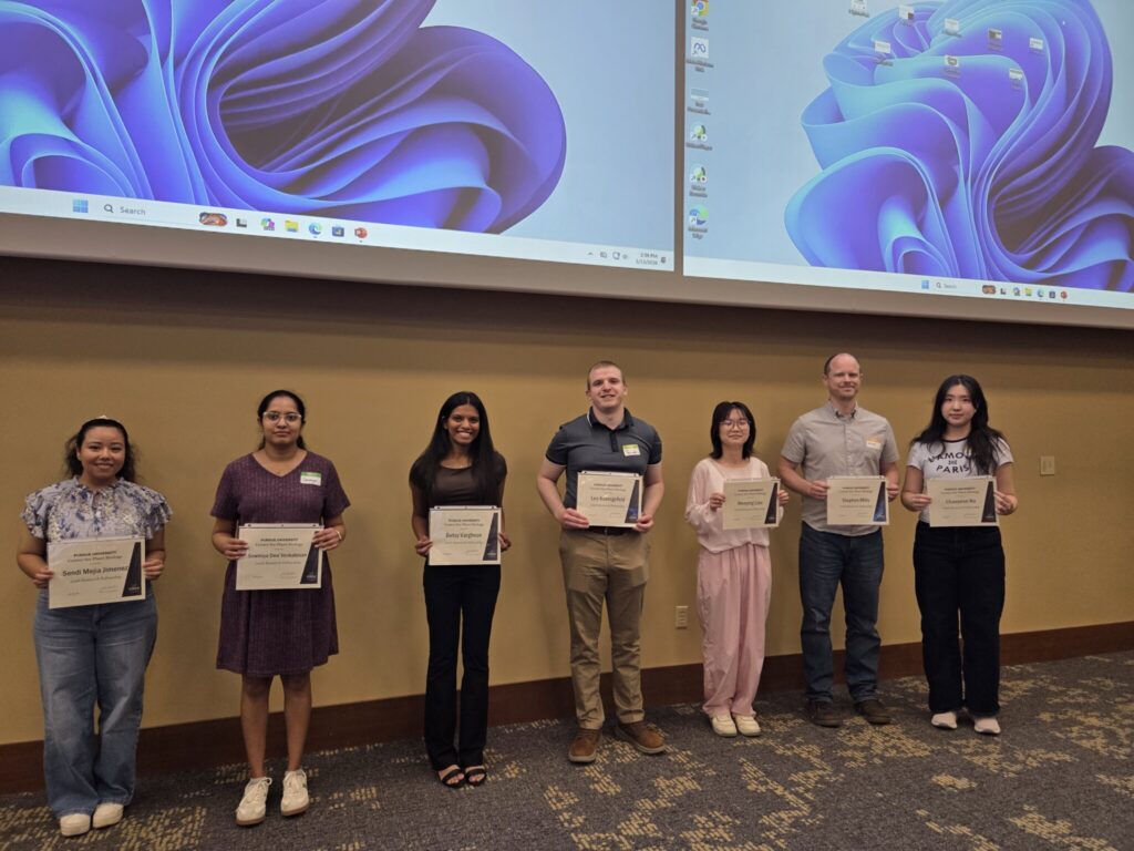 Research fellowship recipients pose with certificates at the Center for Plant Biology retreat awards session.